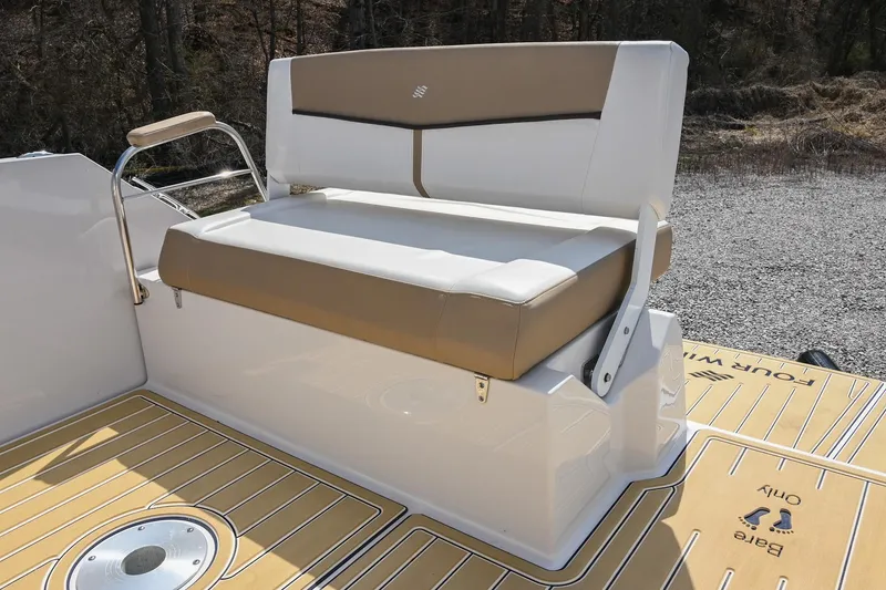 Slide: The Image of 2014 Four Winns V275 boat seat with tan and white upholstery on deck. - 13