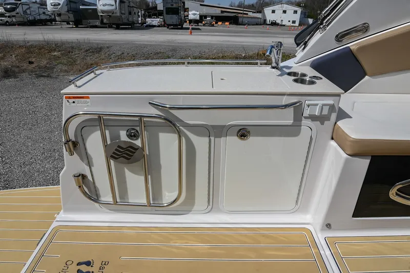Slide: The Image of 2014 Four Winns V275 boat deck with storage compartments and seating area. - 14