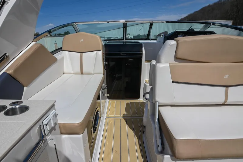 Slide: The Image of 2014 Four Winns V275 boat interior with beige and white seating, sleek design, and modern amenities. - 18