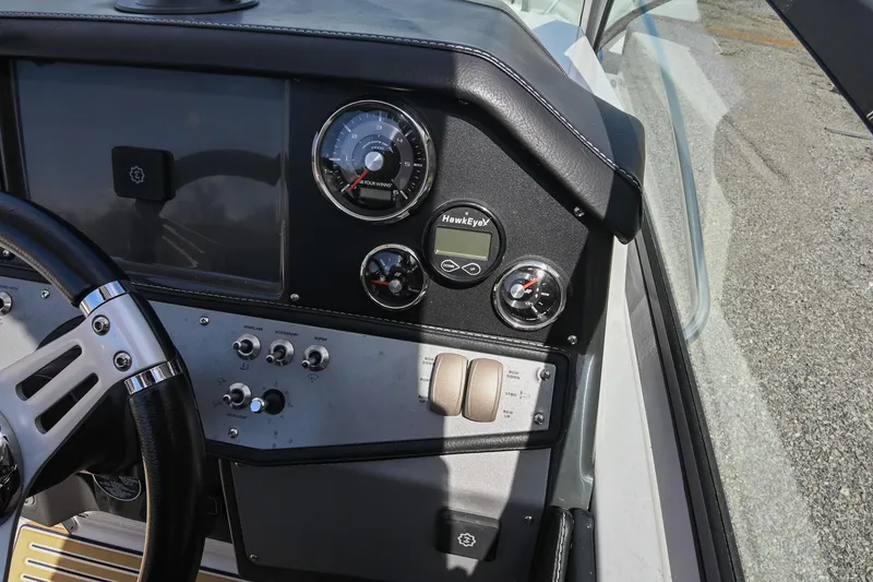 Slide: The Image of 2014 Four Winns V275 boat dashboard with steering wheel and control gauges. - 26