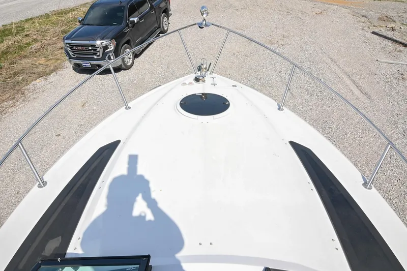 Slide: The Image of 2014 Four Winns V275 boat bow with parked truck in background. - 30