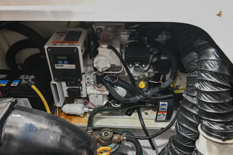 Slide: The Image of Engine compartment of a 2014 Four Winns V275 boat, featuring mechanical components and wiring. - 33