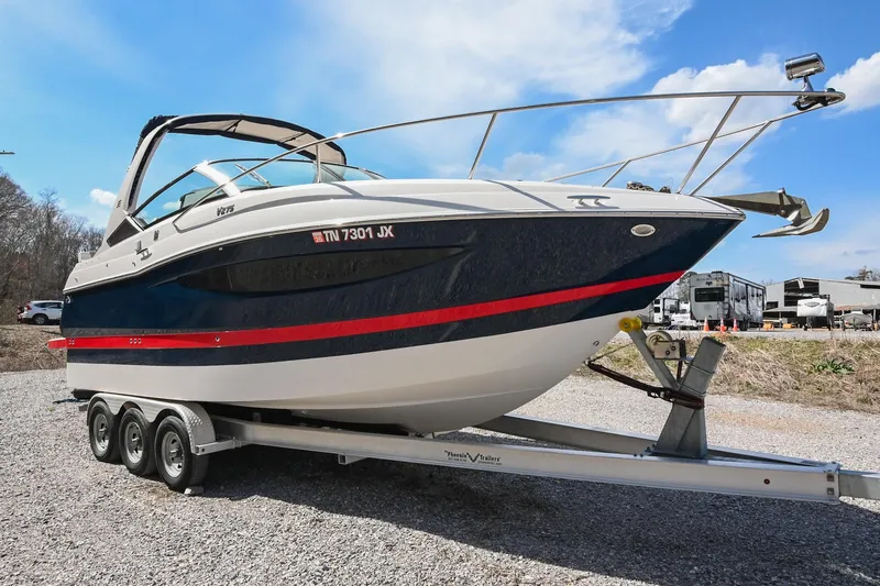 Slide: The Image of 2014 Four Winns V275 boat on a trailer, parked outdoors under a clear sky. - 7
