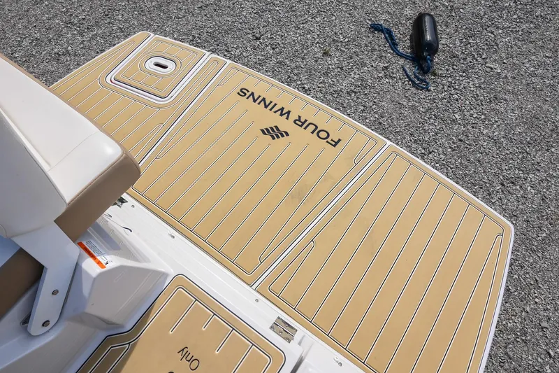 Slide: The Image of 2014 Four Winns V275 boat deck with tan non-slip surface and logo. - 8