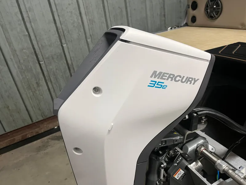 Slide: The Image of 2025 Harris Cruiser 210 with Mercury 35e outboard motor in a garage setting. - 5