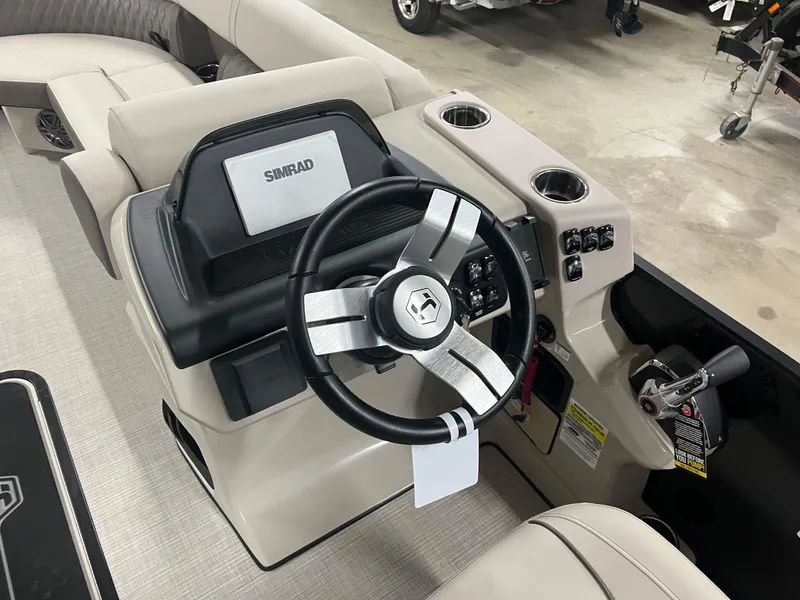 Slide: The Image of 2025 Harris Sunliner 230 boat dashboard with steering wheel and Simrad display. - 11