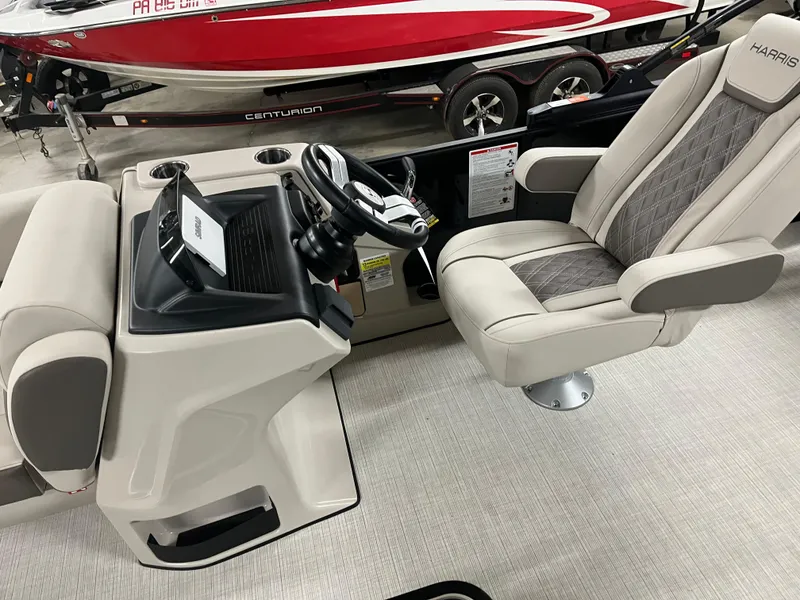 Slide: The Image of 2025 Harris Sunliner 230 boat interior with steering console and plush seating. - 2