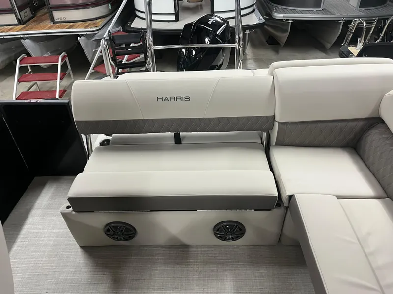 Slide: The Image of 2025 Harris Sunliner 230 boat interior with beige seating and integrated speakers. - 4