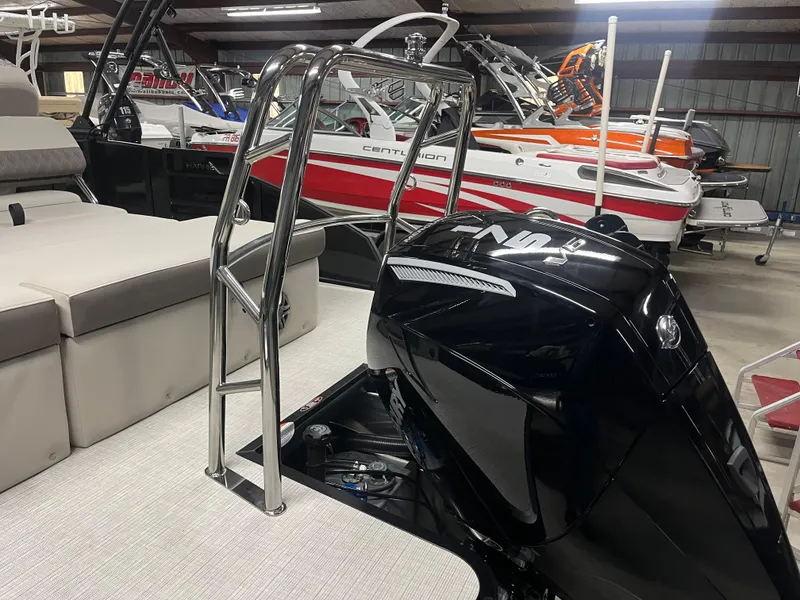 Slide: The Image of 2025 Harris Sunliner 230 boat interior with engine and seating in showroom. - 7