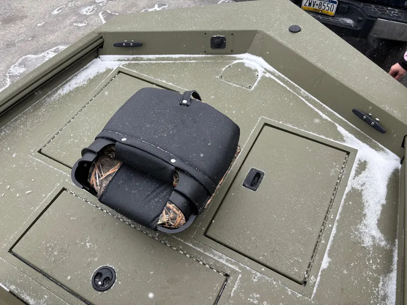 Slide: The Image of 2025 Crestliner 1660 Retriever FCC boat deck with snow and storage compartments. - 8