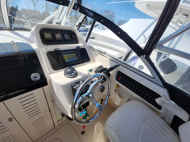 Slide: The Image of 2006 Grady-White Journey 258 boat cockpit with steering wheel and navigation controls. - 11