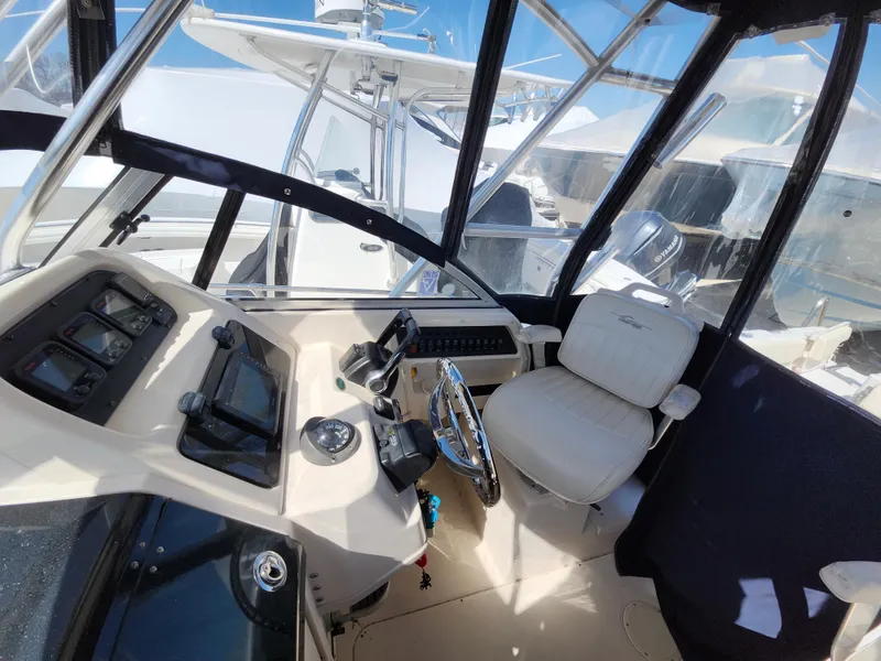 Slide: The Image of 2006 Grady-White Journey 258 boat cockpit with steering wheel and controls. - 12