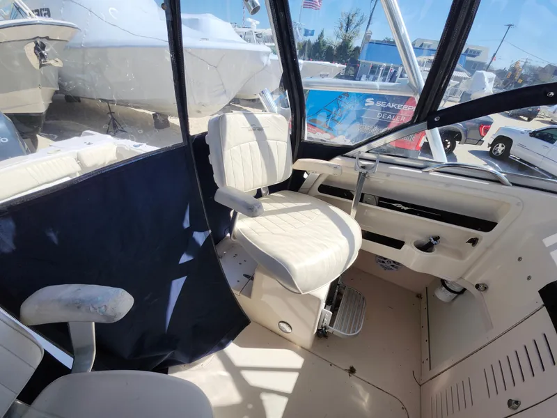 Slide: The Image of 2006 Grady-White Journey 258 boat interior with helm seat and controls. - 14