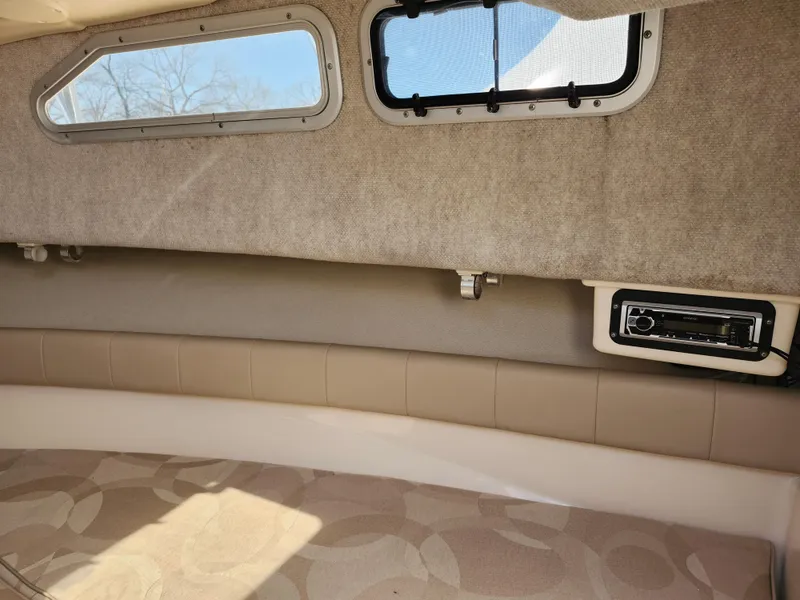 Slide: The Image of 2006 Grady-White Journey 258 cabin interior with windows and cushioned seating. - 27