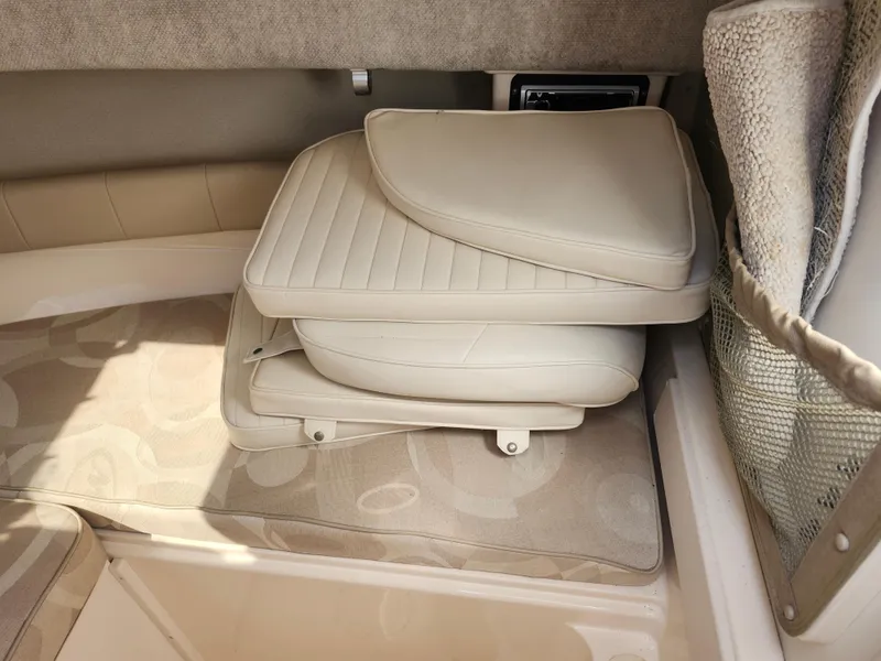 Slide: The Image of 2006 Grady-White Journey 258 cabin interior with stacked beige cushions. - 28