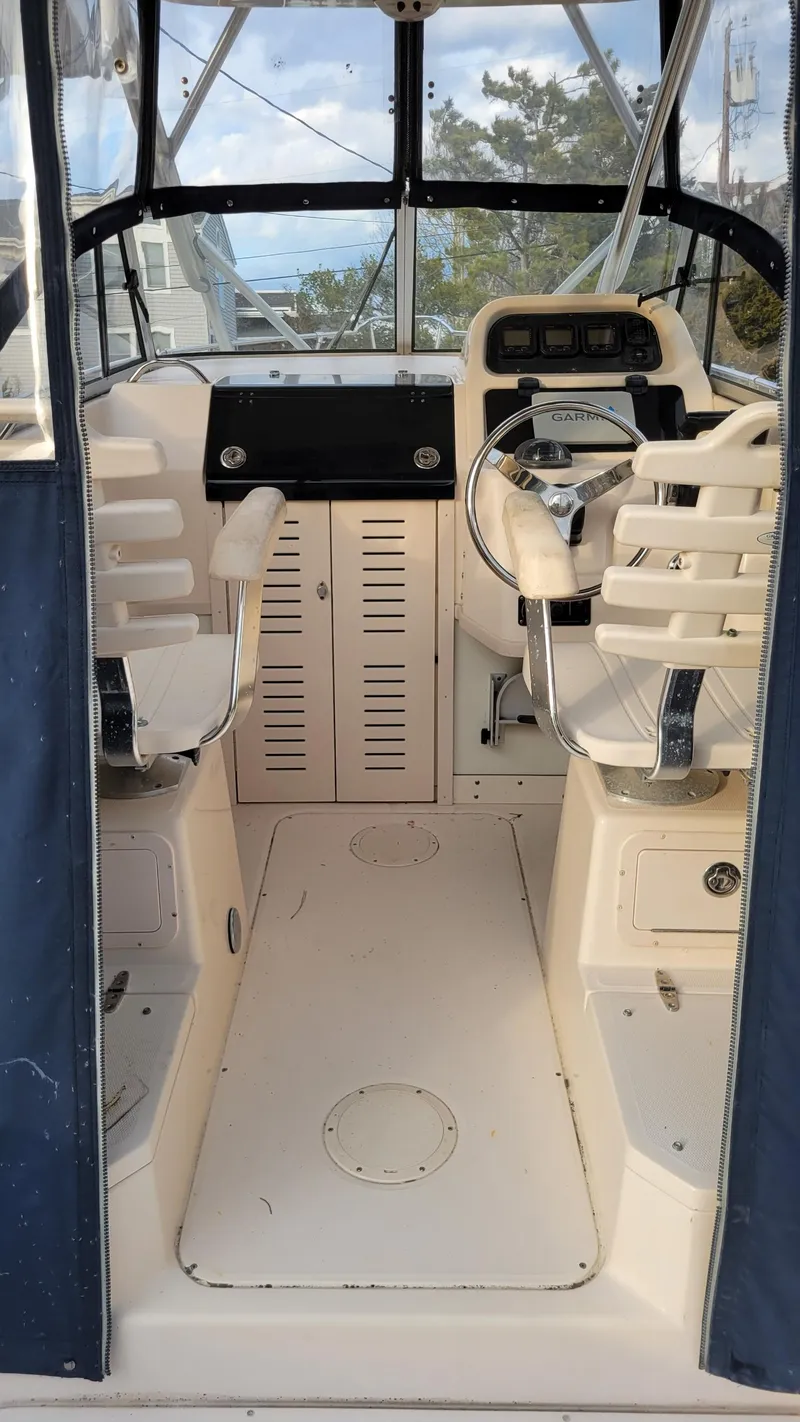 Slide: The Image of 2006 Grady-White Journey 258 boat interior with steering wheel and seating. - 29