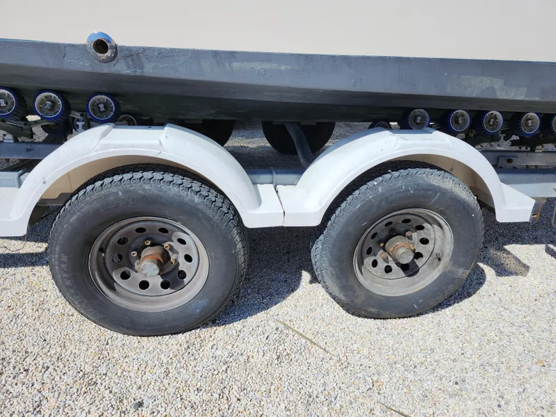 Slide: The Image of Trailer wheels of a 2006 Grady-White Journey 258 boat on gravel surface. - 39