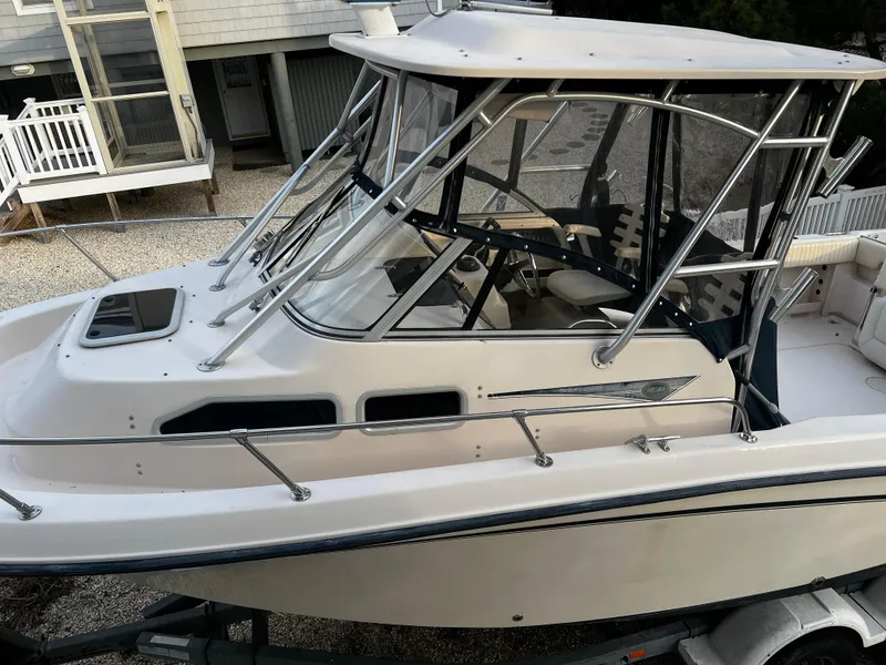 Slide: The Image of 2006 Grady-White Journey 258 boat with enclosed cabin, docked outdoors. - 4