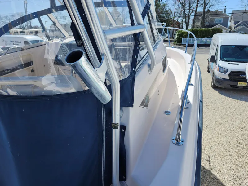 Slide: The Image of 2006 Grady-White Journey 258 boat with blue canopy and stainless steel railings. - 9