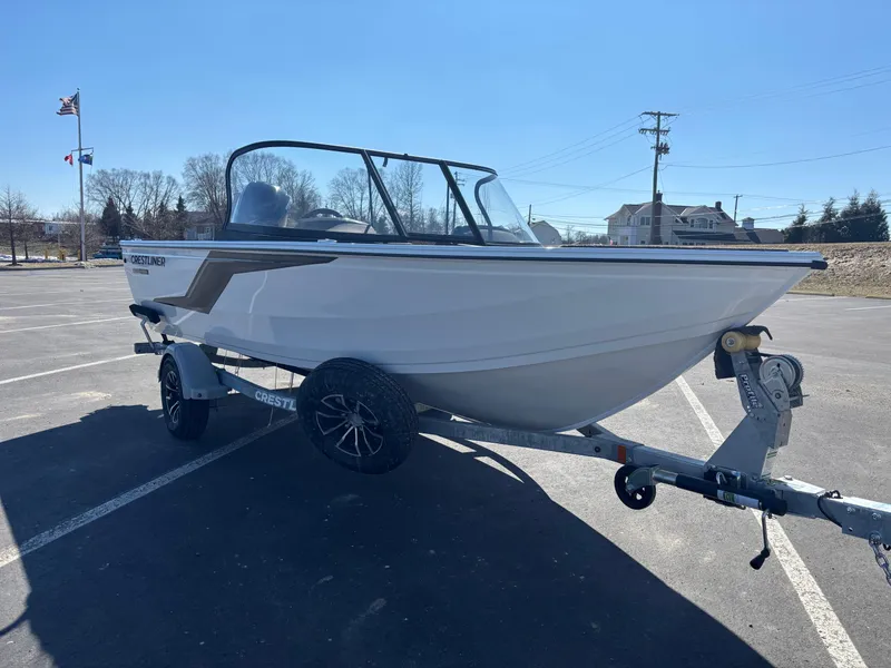 Slide: The Image of 2025 Crestliner 1750 Hawk boat on trailer in parking lot, clear sky background. - 3