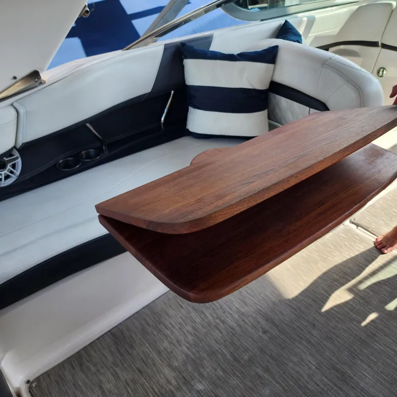 Slide: The Image of Interior of 2018 Regal 26 FasDeck boat with wooden table and cushioned seating. - 12