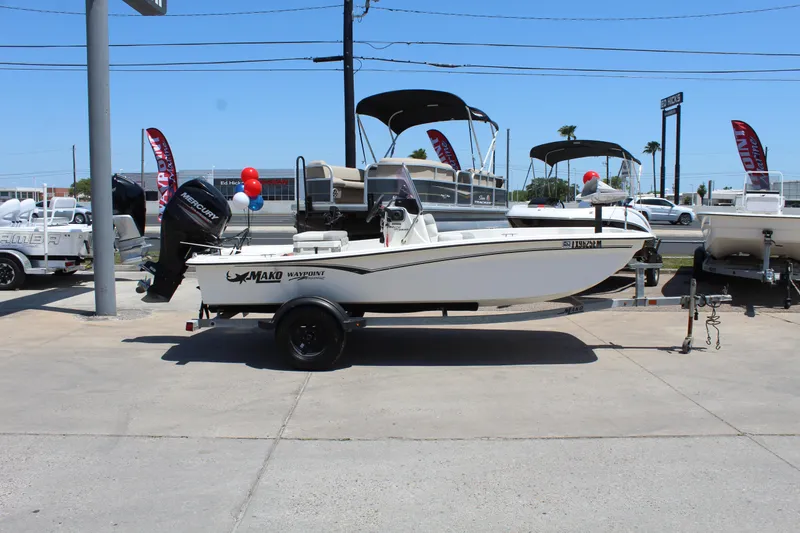 Slide: The Image of 2019 Mako Pro Skiff 15 CC boat on trailer at dealership, surrounded by other boats. - 4