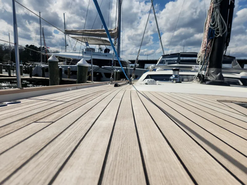 Slide: The Image of 2023 Hallberg-Rassy 57 yacht deck with marina view and cloudy sky. - 12