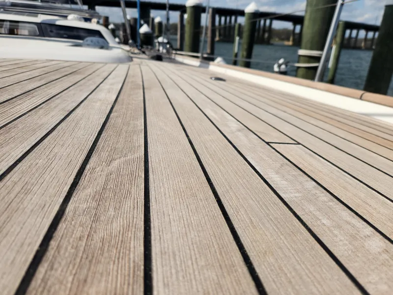 Slide: The Image of Teak deck of 2023 Hallberg-Rassy 57 yacht at a marina. - 13