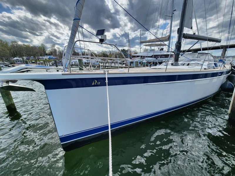 Slide: The Image of 2023 Hallberg-Rassy 57 yacht docked, showcasing sleek design and modern features. - 2