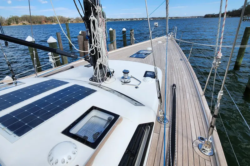 Slide: The Image of 2023 Hallberg-Rassy 57 yacht deck with solar panels, docked by the water. - 22
