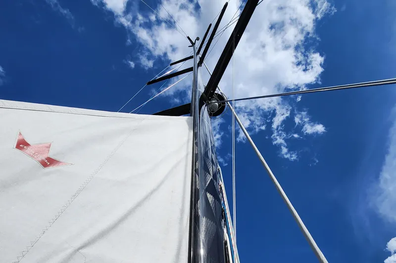 Slide: The Image of Hallberg-Rassy 57 sailboat mast and sail against a blue sky, 2023 model. - 25