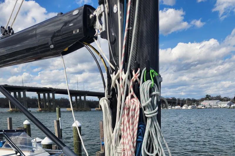 Slide: The Image of 2023 Hallberg-Rassy 57 sailboat mast and rigging by a waterfront marina. - 29