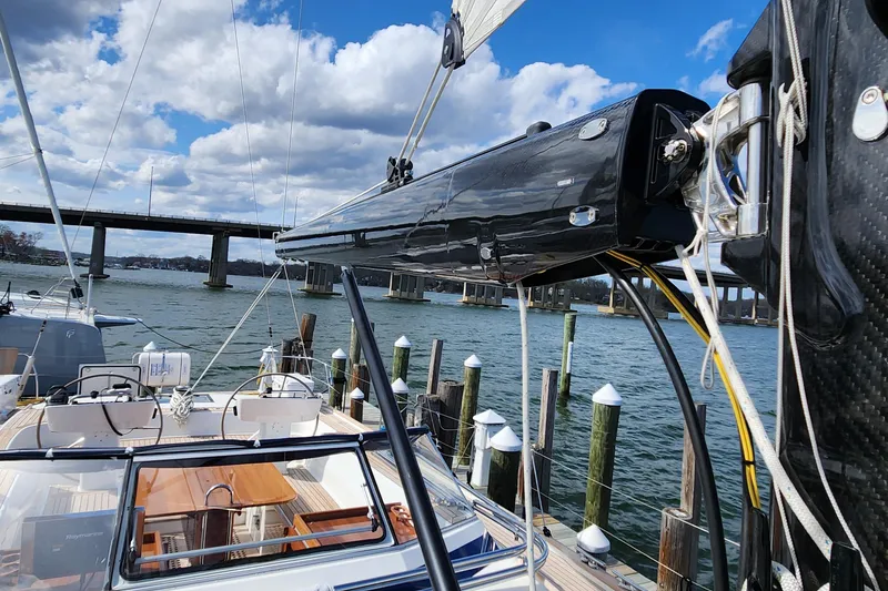 Slide: The Image of 2023 Hallberg-Rassy 57 yacht docked by a bridge under a partly cloudy sky. - 34
