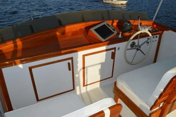 Slide: The Image of 1990 Stanley 36' Downeast Fly Bridge Cruise interior with wooden helm and seating. - 11