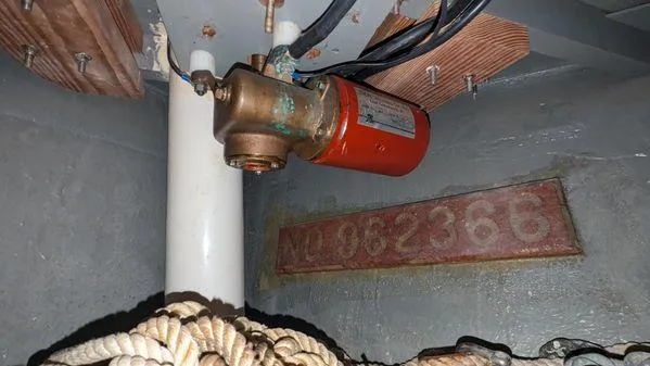 Slide: The Image of 1990 Stanley 36' Downeast Fly Bridge Cruise engine room with pump and ropes. - 21