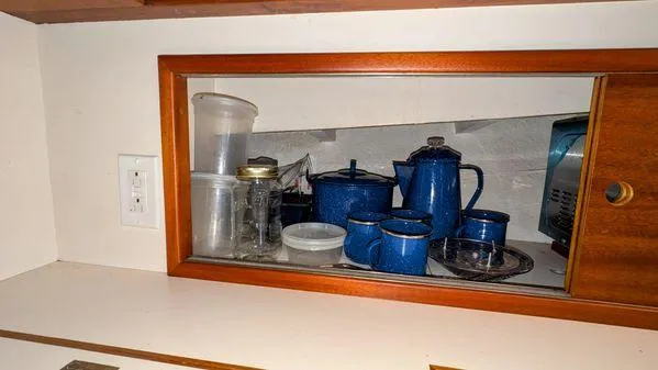 Slide: The Image of Cabinet with blue enamel cookware on Stanley 36' Downeast Fly Bridge Cruise, 1990 model. - 27