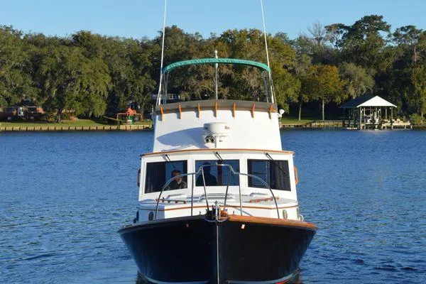 Slide: The Image of 1990 Stanley 36' Downeast Fly Bridge Cruise boat on a serene lake. - 49