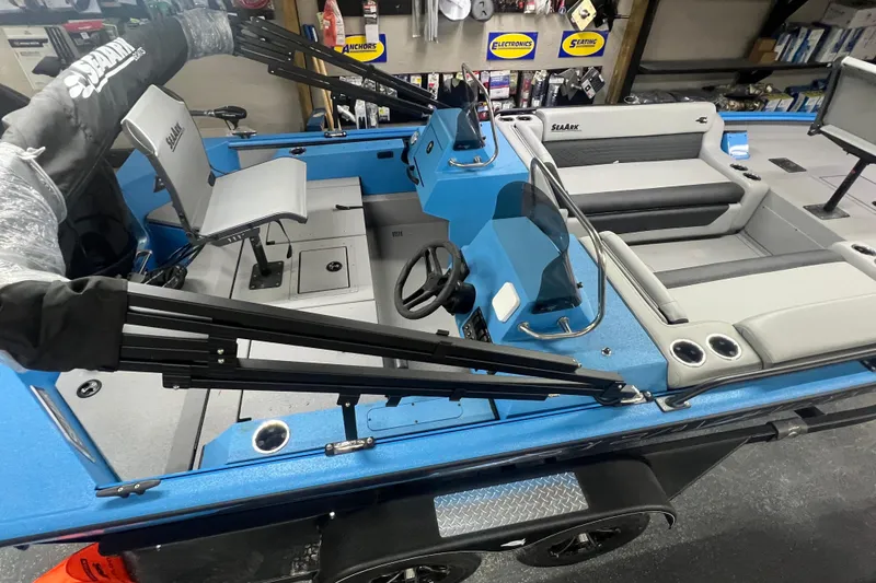 Slide: The Image of 2026 SeaArk Easy 200 boat interior with blue and gray seating, steering wheel, and storage compartments. - 25