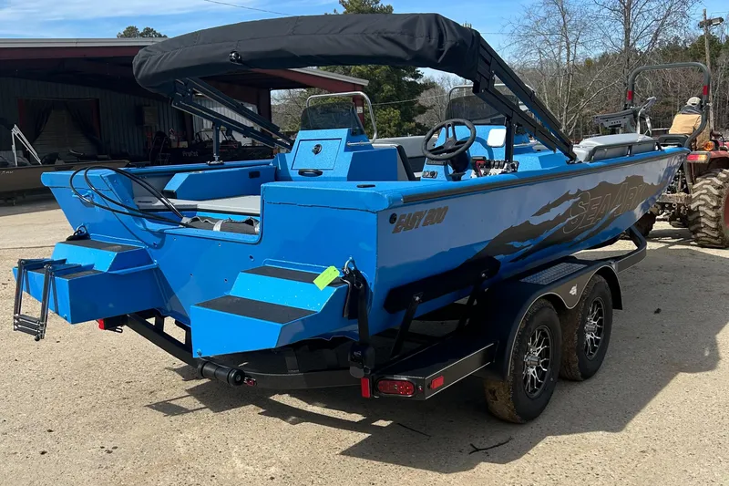 Slide: The Image of 2025 SeaArk Easy 200 boat on trailer at sunset, featuring blue exterior and sleek design. - 5