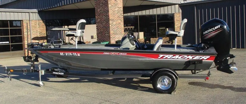 The Image of 2017 Tracker Pro Team™ 195 TXW fishing boat on trailer, parked outside a building. - 1