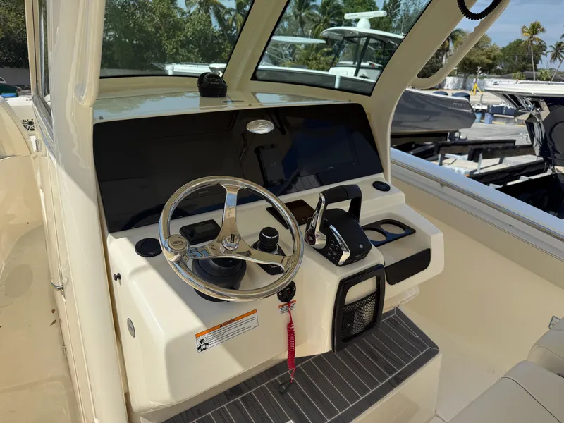 Slide: The Image of 2025 Scout 305 LXF boat helm with steering wheel and controls. - 12