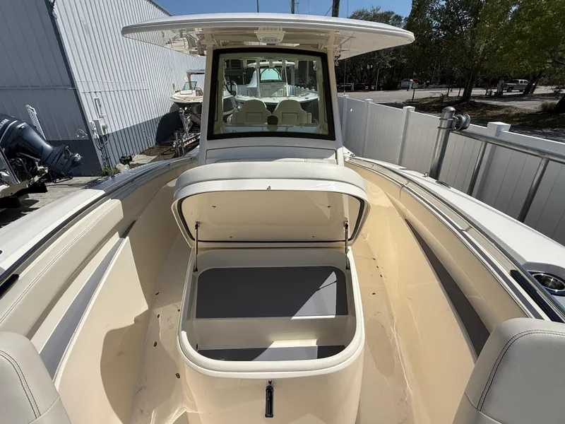 Slide: The Image of 2025 Scout 305 LXF boat interior with open storage compartment, showcasing spacious seating and modern design. - 19