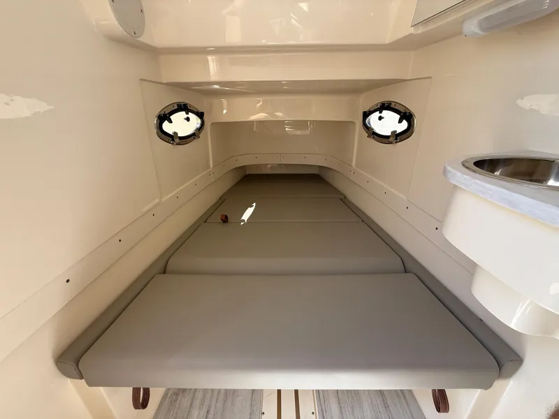Slide: The Image of 2025 Scout 305 LXF cabin interior with cushioned seating and portholes. - 20