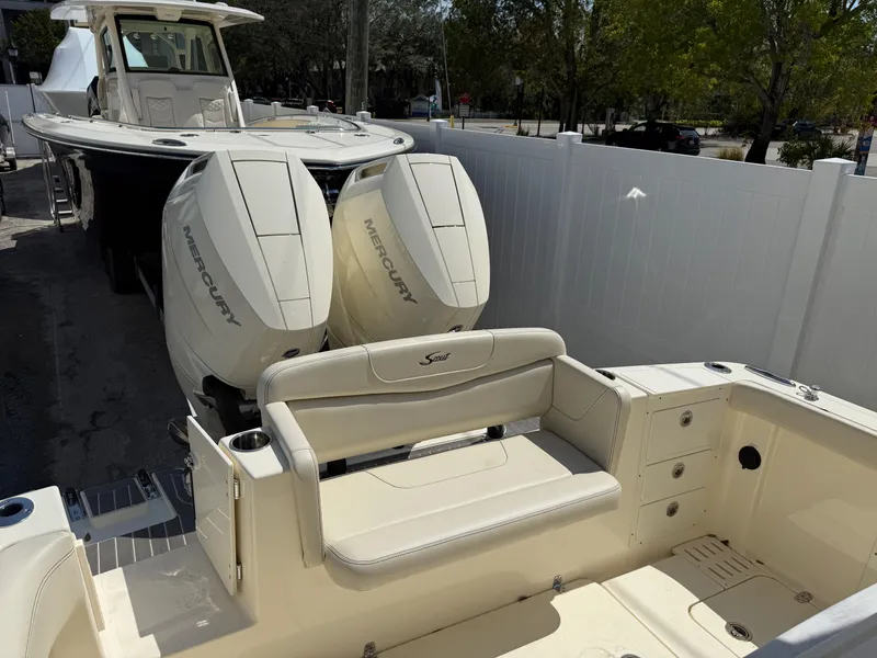 Slide: The Image of 2025 Scout 305 LXF boat with dual Mercury engines, featuring a spacious seating area. - 7