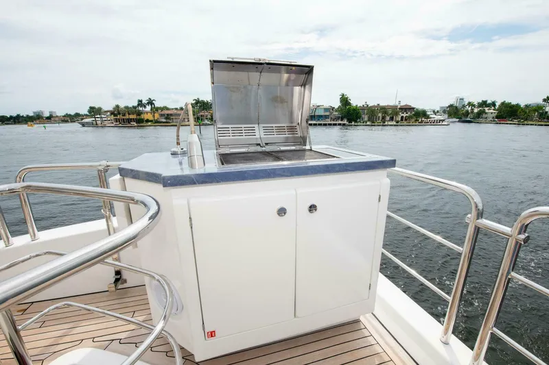 Slide: The Image of 2017 Azimut 84 Flybridge yacht with outdoor grill on deck, overlooking serene waterfront. - 28