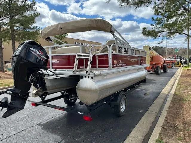 Slide: The Image of 2023 Sun Tracker Party Barge 18 DLX pontoon boat on trailer, parked outdoors. - 3