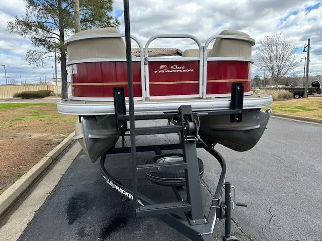 Slide: The Image of 2023 Sun Tracker Party Barge 18 DLX pontoon boat on trailer, parked outdoors. - 4