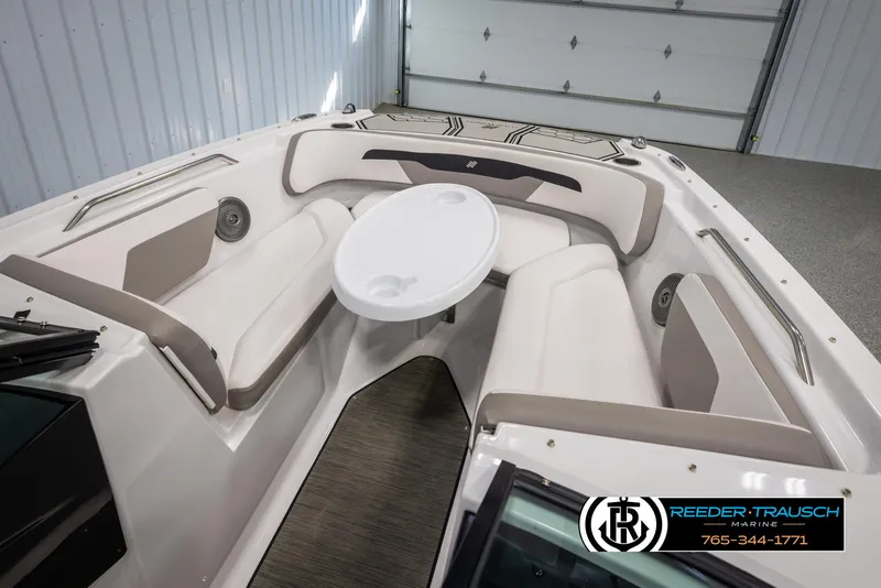 Slide: The Image of 2019 Four Winns HD200 boat interior with seating and table in a garage. - 20