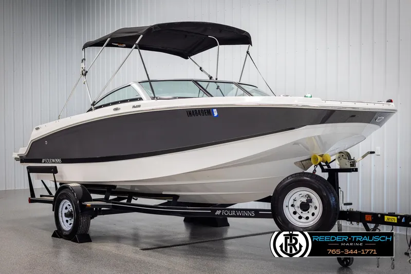 Slide: The Image of 2019 Four Winns HD200 boat on trailer with canopy, displayed indoors. - 3
