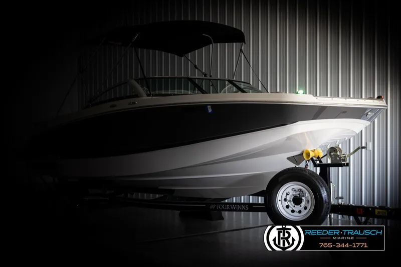 Slide: The Image of 2019 Four Winns HD200 boat in a dimly lit showroom on a trailer. - 4